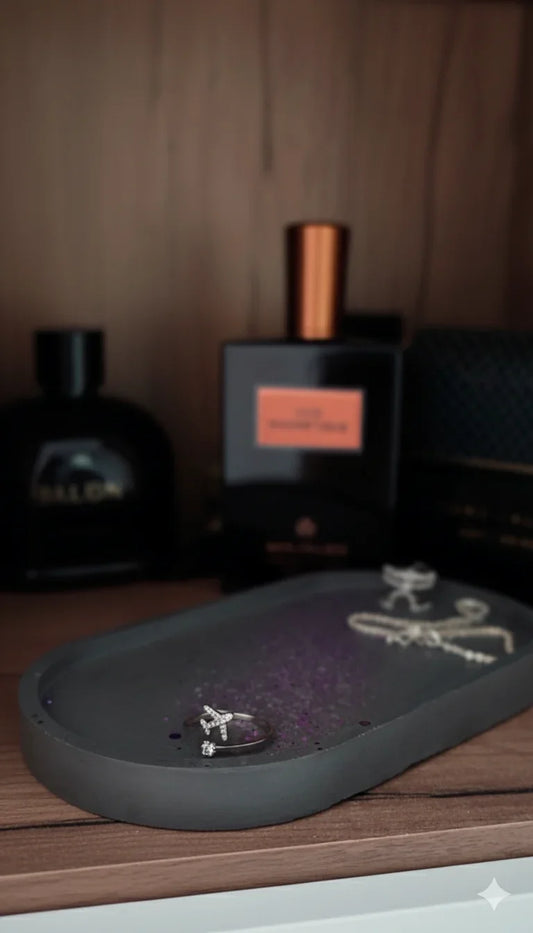 Elegante Schmuckablage mit silbernem Ring, im Hintergrund exklusive Parfümflakons, stilvoll dekoriert