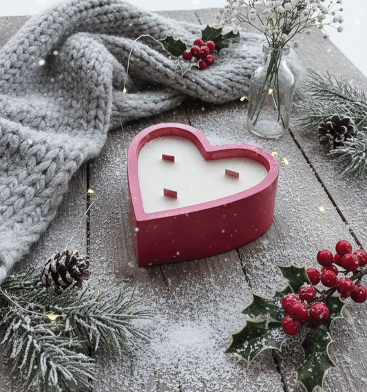 Herzförmige TRISKIT Aromakerze im Winterdekor mit Beeren, Tannenzweigen und Wollschal